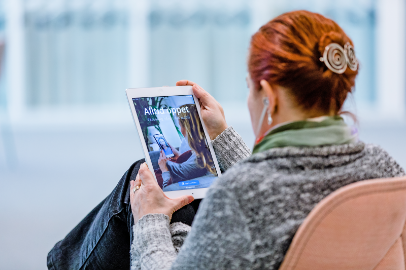 En person tittar på vård-appen Alltid öppet på en surfplatta